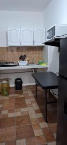 eine Küche mit weißen Schränken und einem Tisch darin in der Unterkunft El Ausente in Ciudad Valles