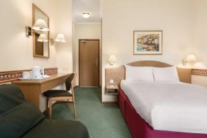 a hotel room with a bed and a desk and a chair at Days Inn by Wyndham Donington in Castle Donington +23 photos