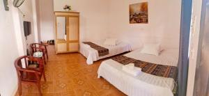 a room with three beds in a room at Hong Minh Guesthouse in Mù Cang Chải