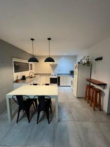 Una cocina con mesa y sillas y un refrigerador. en Casa Serena Rio, en Viedma 7 fotos más