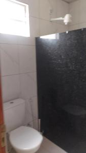 a bathroom with a toilet and a shower with a window at Restaurante e Petiscaria Tucunaré Azul in Coruripe