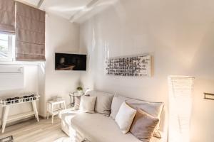 a white living room with a white couch and paintings at Vatican Sweet Home in Rome