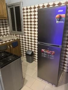 a kitchen with a refrigerator with a pineapple on it at Tige logement in Dakar