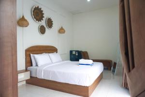 a bedroom with a bed with white sheets and pillows at M Bali 2 in Ngaglik