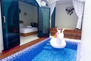 a room with a pool with a toy unicorn in it at M Bali 2 in Ngaglik