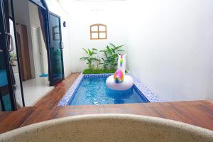 a swimming pool with a candle in the middle of a house at M Bali 2 in Ngaglik +5 photos