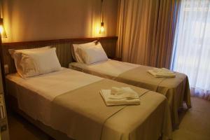 two beds in a hotel room with towels on them at Mar Azul Boutique Hotel in Icapuí +26 photos