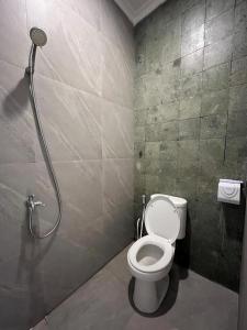 a bathroom with a toilet and a shower at Sampai Town Hotel in Adi Sutjipto