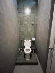 a small bathroom with a toilet in a stall at Sampai Town Hotel in Adi Sutjipto