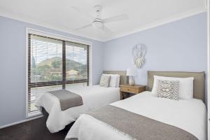 Un dormitorio blanco con dos camas y una ventana. en 32 Degrees South, 40 Government Rd - Pet Friendly, Linen, Air Con, WiFi, en Shoal Bay