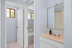 un baño con lavabo y espejo en 32 Degrees South, 40 Government Rd - Pet Friendly, Linen, Air Con, WiFi, en Shoal Bay 28 fotos más