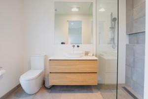 a bathroom with a sink and a toilet and a shower at Luxury Avenue Retreat-Sleeps 8, Fireplace, Central, Garage, 4 bedroom, 2 bathroom, BBQ in Ocean Grove +17 photos