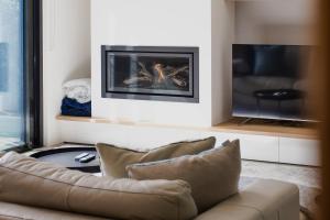 a living room with a couch and a tv at Luxury Avenue Retreat-Sleeps 8, Fireplace, Central, Garage, 4 bedroom, 2 bathroom, BBQ in Ocean Grove