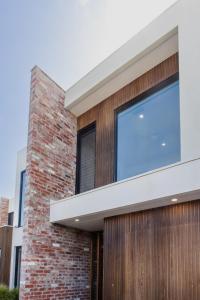 a facade of a brick building with a window at Luxury Avenue Retreat-Sleeps 8, Fireplace, Central, Garage, 4 bedroom, 2 bathroom, BBQ in Ocean Grove
