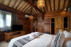 Postel nebo postele na pokoji v ubytování Oemah Joglo 2 Ubud