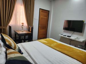 a hotel room with a bed and a television at Summerville Hotel and Resort in Palayan City