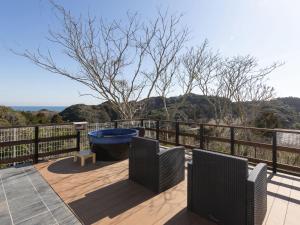eine Terrasse mit zwei Stühlen und einem blauen Eimer auf einem Zaun in der Unterkunft ALL SEASON RESORT No4 Tenku in Chōjamachi