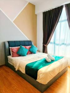 a bed with colorful pillows in a room with a window at Grand Horizon Imperium Residence Kuantan Studio City view in Kuantan