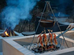 eine Gruppe von Fleischgerichten auf einem Grill mit Kamin in der Unterkunft ALL SEASON RESORT No4 Tenku in Chōjamachi