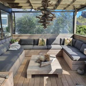 a living room with a couch and a table at Beachfront Sunset Bach in Piha