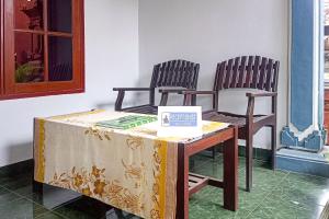 two chairs sitting next to a table with a tablecloth at Astri Homestay Carkranegara Mataram Mitra RedDoorz in Tjakranegara +15 photos