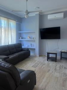 a living room with a couch and a flat screen tv at Laguna beach in Sosúa