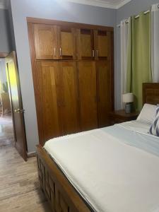 a bedroom with a large bed and wooden cabinets at Laguna beach in Sosúa