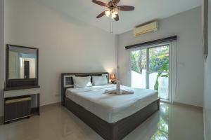 a bedroom with a bed with a ceiling fan and a window at V174 Great Base 2 Explore Phuket Everting you Need in Phuket Town +41 photos