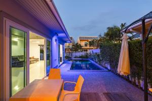 a house with a table and chairs next to a swimming pool at V174 Great Base 2 Explore Phuket Everting you Need in Phuket Town