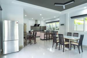 a kitchen with a table and chairs and a refrigerator at V174 Great Base 2 Explore Phuket Everting you Need in Phuket Town