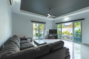 a living room with a couch and a tv at V174 Great Base 2 Explore Phuket Everting you Need in Phuket Town