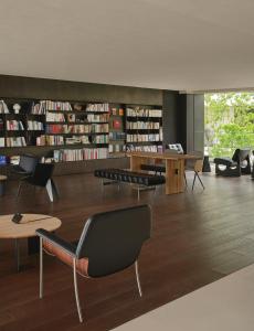 biblioteca con sedie, tavoli e librerie di 西塘光向度艺术酒店WNDR Hotel Xitang a Jiaxing