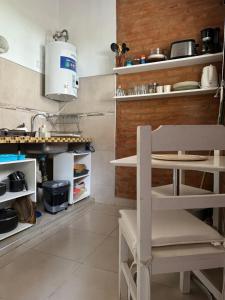 a kitchen with a table and a chair in it at El marinero puerto pirámides in Puerto Pirámides +14 photos