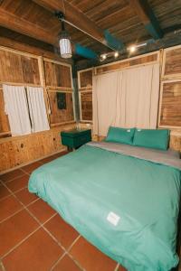 a large bed in a room with wooden walls at Homestay Nhà Mầm in Da Thien