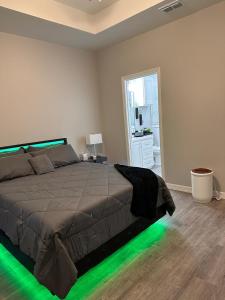 a bedroom with a bed with green lights on the floor at Doho-Enterprise Villa in Weslaco
