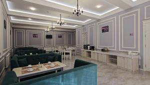 a restaurant with green chairs and tables in a room at OLD STATION HOTEL in Samarkand
