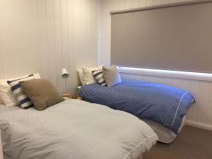 a bedroom with a bed and a pillow at Coastal White House in Point Lonsdale
