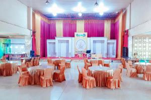 a room with tables and chairs and pink curtains at Urbanview at Wedika Hotel Bengkulu in Bengkulu