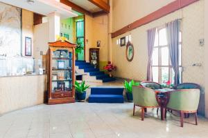 a room with a table and chairs and a staircase at Urbanview at Wedika Hotel Bengkulu in Bengkulu
