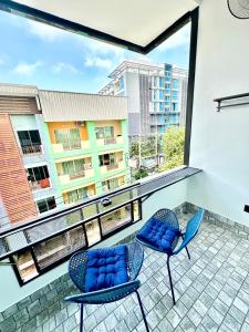een balkon met 2 stoelen en uitzicht op een gebouw bij VIRAPLACe 4# in Pattaya
