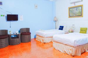 a room with two beds and a flat screen tv at Urbanview at Wedika Hotel Bengkulu in Bengkulu +27 photos