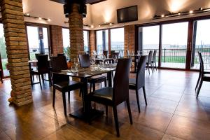 uma sala de jantar com mesas, cadeiras e janelas em Restaurace&Rooms Na Jitrách em Semice