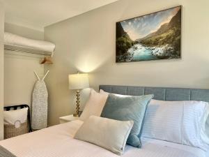 a bedroom with a bed and a painting on the wall at Mountain View New Luxury Condo at Banff Entrance in Canmore