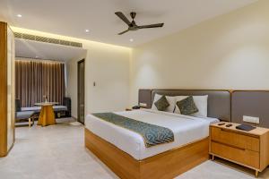 a bedroom with a large bed with a ceiling fan at Hotel Sannidhi Emerald in Raigīr