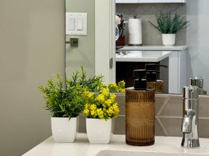 three vases with flowers on a counter in a kitchen at Mountain View New Luxury Condo at Banff Entrance in Canmore +73 photos