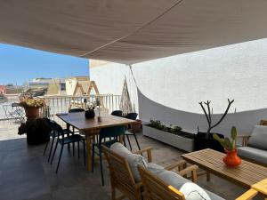 patio ze stołami i krzesłami na dachu w obiekcie B&B CASA GILANIA LAMPEDUSA w mieście Lampedusa
