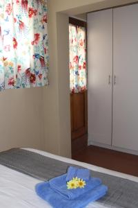 een slaapkamer met een bed met een blauwe handdoek erop bij Klein Morgenster B&B in Johannesburg