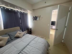 a bedroom with a large bed with pillows on it at Amoore Avida Tower 2 in Cagayan de Oro
