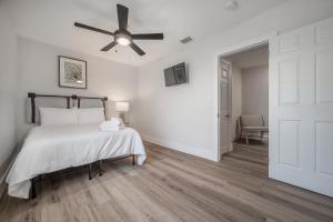 una camera da letto bianca con un letto e un ventilatore a soffitto di 701 W Indiana Ave a Tampa Altre 17 foto