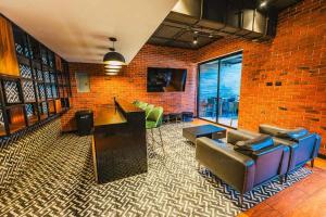 a room with couches and a brick wall at Loft urbano, Ciudad Guatemala, EON in Estación Pamplona